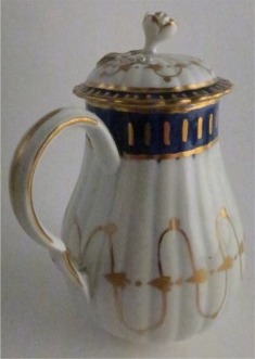 Worcester Pear Shaped Milk Jug and Cover, moulded fluted body, shallow domed cover with flower finial. Decorated in underglaze cobalt blue and rich gilding, c1775