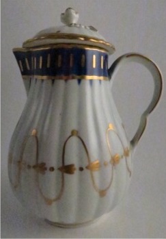 Worcester Pear Shaped Milk Jug and Cover, moulded fluted body, shallow domed cover with flower finial. Decorated in underglaze cobalt blue and rich gilding, c1775