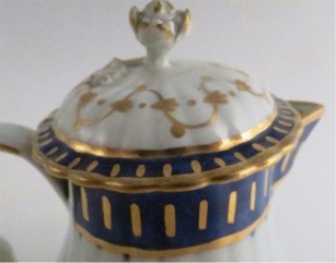 Worcester Pear Shaped Milk Jug and Cover, moulded fluted body, shallow domed cover with flower finial. Decorated in underglaze cobalt blue and rich gilding, c1775