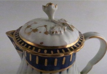 Worcester Pear Shaped Milk Jug and Cover, moulded fluted body, shallow domed cover with flower finial. Decorated in underglaze cobalt blue and rich gilding, c1775
