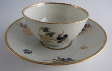 Worcester Tea Bowl and Saucer, Decorated in Underglaze Blue with Formal Flowers, Honey Gold Leaves and Stems, Gold Dentil Rim and Base, c1785