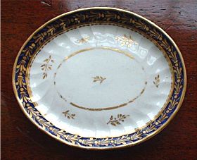 The cabinet displayed a few items of porcelain, including cups and saucers, one of which I recognised as New Hall, pattern 243 (a pattern also used by Chamberlain Worcester). This is a shanked cup and saucer, with cobalt blue bands to the edges, decorated with gilt foliage, almost in the form of a Flue-de-lies.