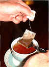 The simple trick is to use the teaspoon to lift the bag clear of the tea just above the cup. 