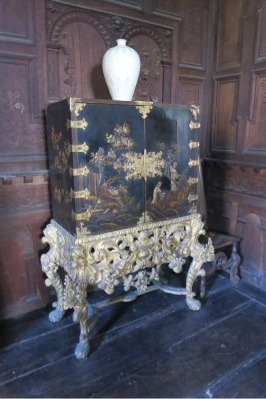 A late 17th century Chinese lacquer cabinet is on a stand made of carved and gilded pine, in the style of Charles II